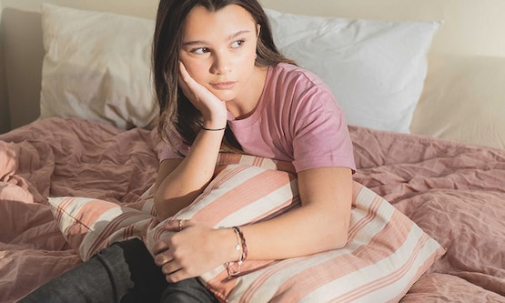 En tjej i yngre tonåren som tänker på första mensen och hur det funkar