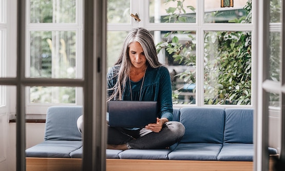 Mature woman on laptop researching menopause symptoms
