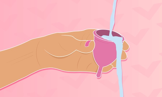 A close-up of an arm rinsing a menstrual cup with water.