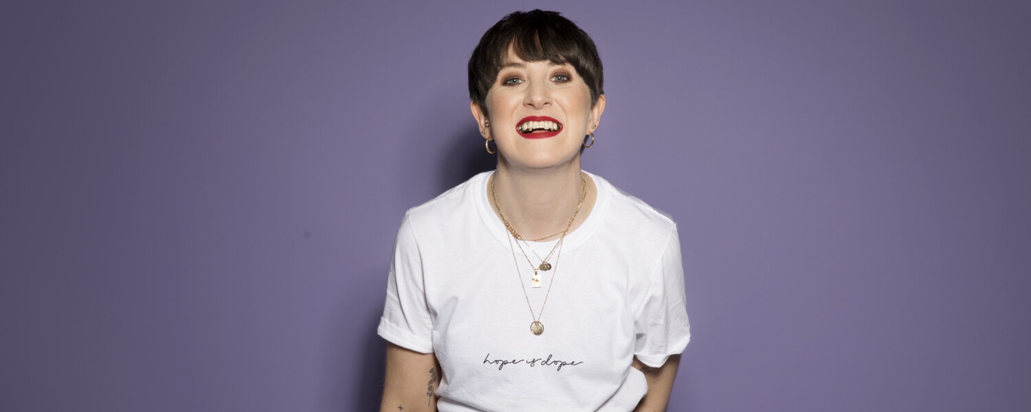 Lauren Mahon smiling against a purple background
