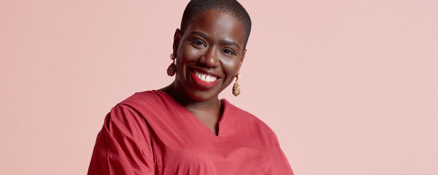 Candice Brathwaite smiling against a pink background