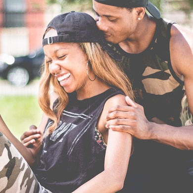 Imagen de una chica y su novio abrazados y riendo - Saba
