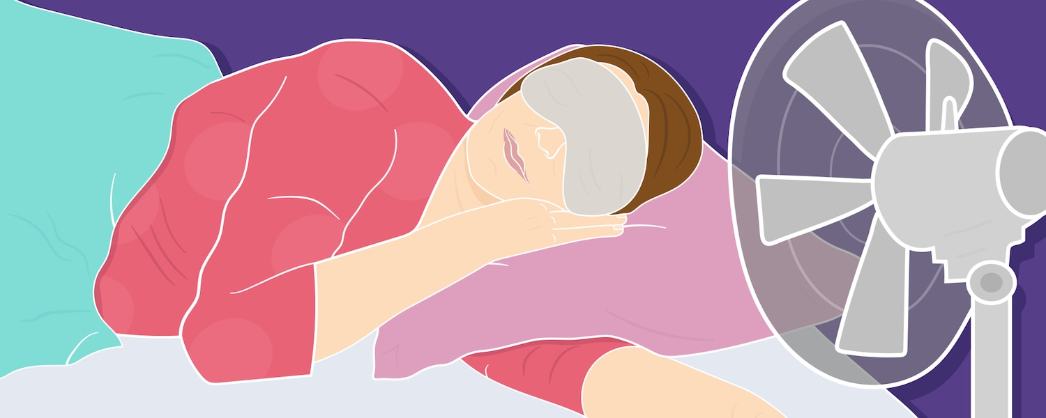 Menopausal woman sleeping in front of a fan wearing an eye mask