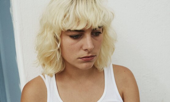 Girl with blonde bob and fringe suffering from premenstrual dysphoric disorder PMDD