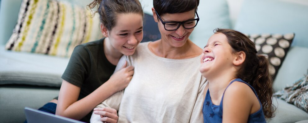 Imagen de una madre y dos hijas riendo y divirtiéndose - Saba