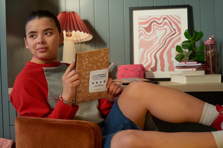Teen girl sat holding a pack of Bodyform period pants