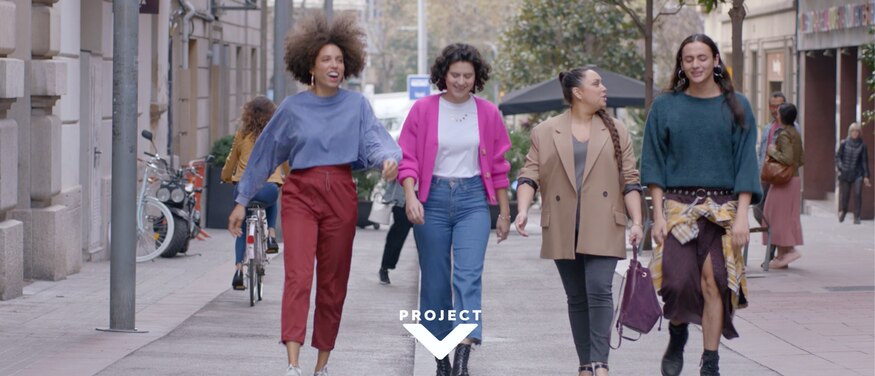 Group of 4 female friends walk down a pedestrianised street