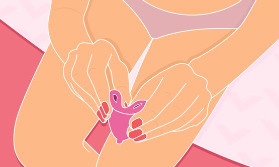 Person folding a menstrual cup for insertion