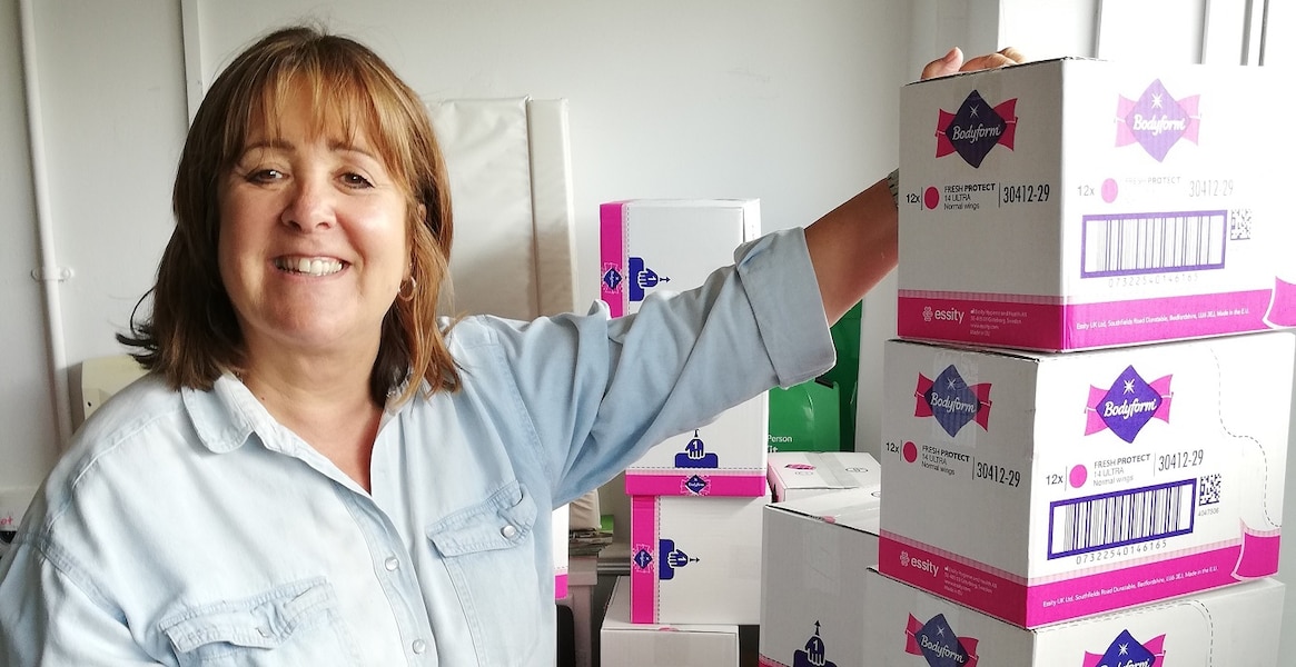 Woman in front of boxes of Bodyform sanitary products