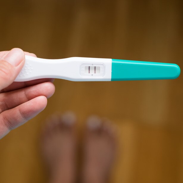 Hand holding positive pregnancy