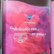 Een jonge vrouw met haar ogen dicht die een t-shirt van de 'Ben je ongesteld ofzo' campagne van Libresse draagt