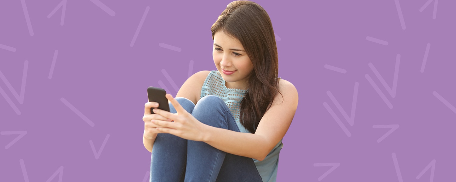 Imagen de una niña leyendo en su teléfono celular sobre un fondo morado - Saba