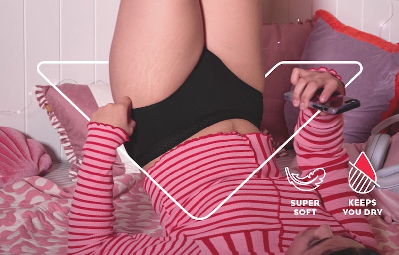 Woman lay on bed in bodyform period pants