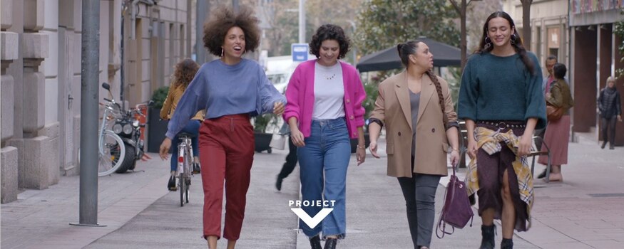 Group of 4 female friends walk down a pedestrianised street