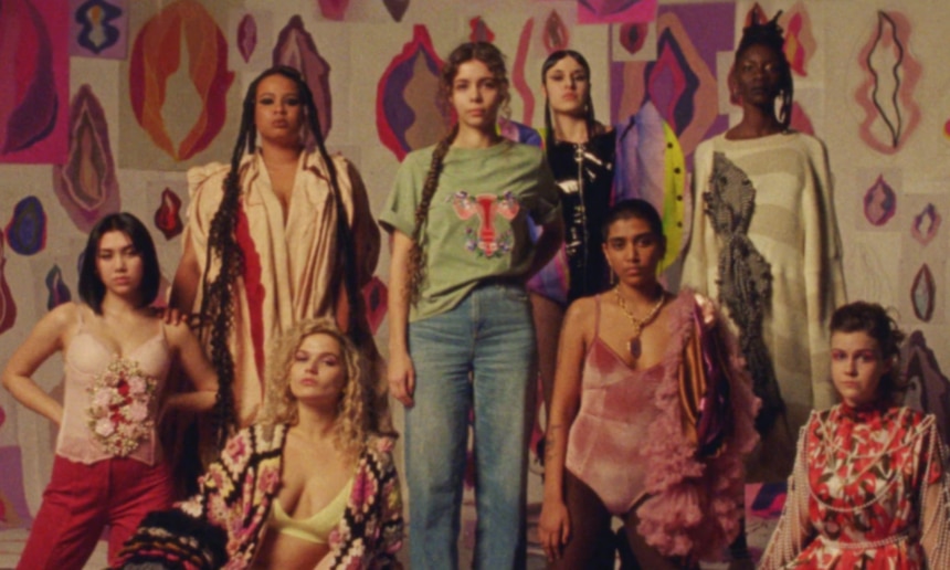 Women+ standing together with vulva illustration in the background